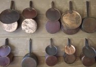 Batterie de cuisine, rows of cooking pans and lids hung on the wall.