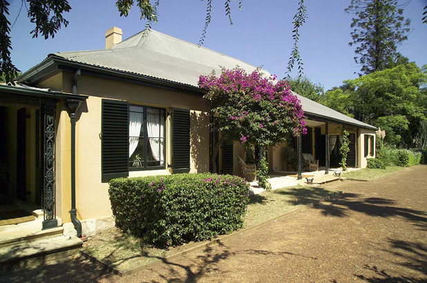 Exterior of Elizabeth Farm, showing the verandah and Bougainvillea in bloom.