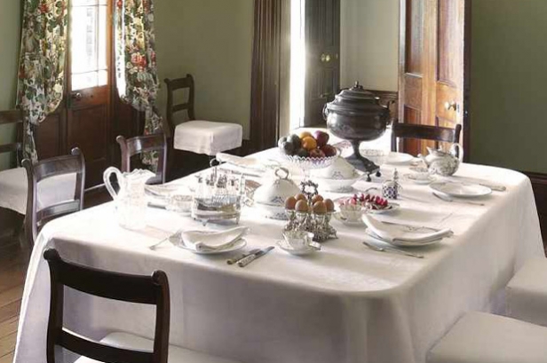 The Elizabeth Farm dining table set for breakfast with eggs, fruit and tea visible on the table.