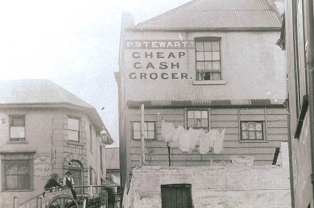 Sign reading 'Cheap Cash Grocer' on the rear of No 64, Susannah Place.