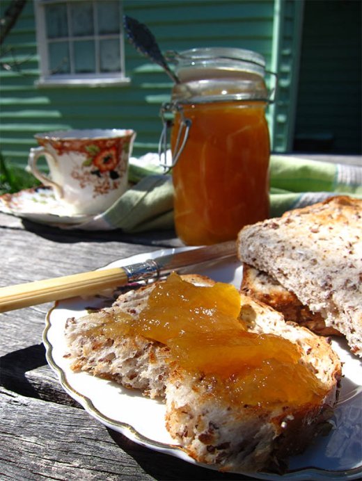 Grapefruit marmalade on bread with a tea cup and saucer.