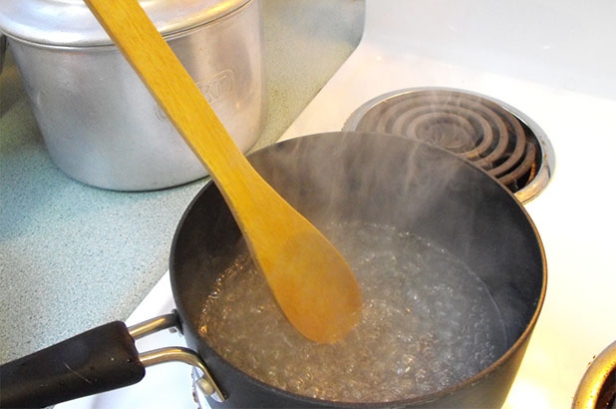 Boiling sugar syrup for spun sugar cake with vintage cake tin in background