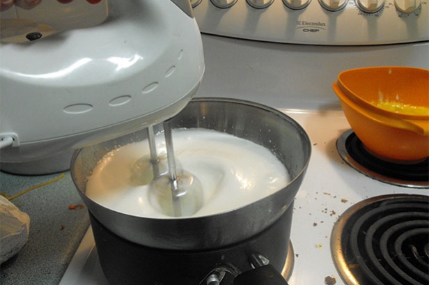 Photograph of boiled icing being beaten over a stovetop.