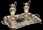 Two silver claret jugs, two silver coasters and a silver presentation tray.