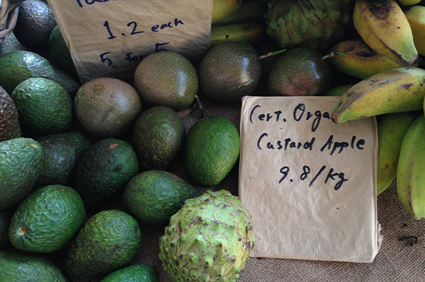 Photograph of a custard apple with other fruits in a market display